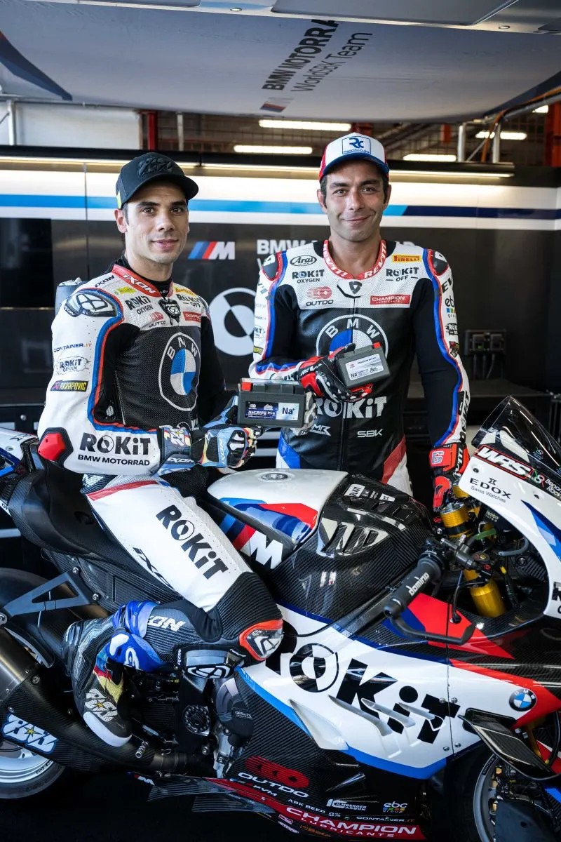 BMW Motorrad WorldSBK Team riders posing with OUTDO NaCR10S Pro and NaCR5SL-VD sodium-ion batteries in the garage