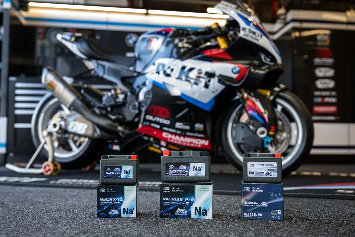 OUTDO NaCRX4L, NaCR10S Pro, and NaCR5SL-VD sodium-ion batteries in front of the ROKiT BMW Motorrad WorldSBK race bike