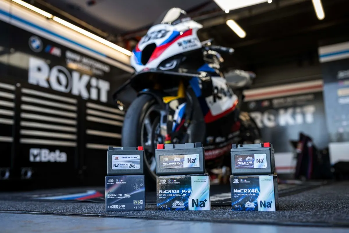 Three OUTDO sodium-ion motorcycle batteries with their boxes on the floor of the BMW Motorrad WorldSBK Team garage
