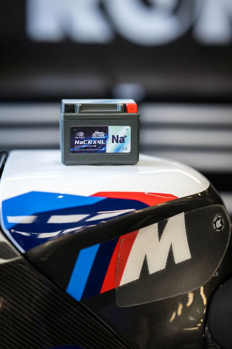 OUTDO NaCRX4L sodium-ion battery resting on the fuel tank of the BMW M race bike